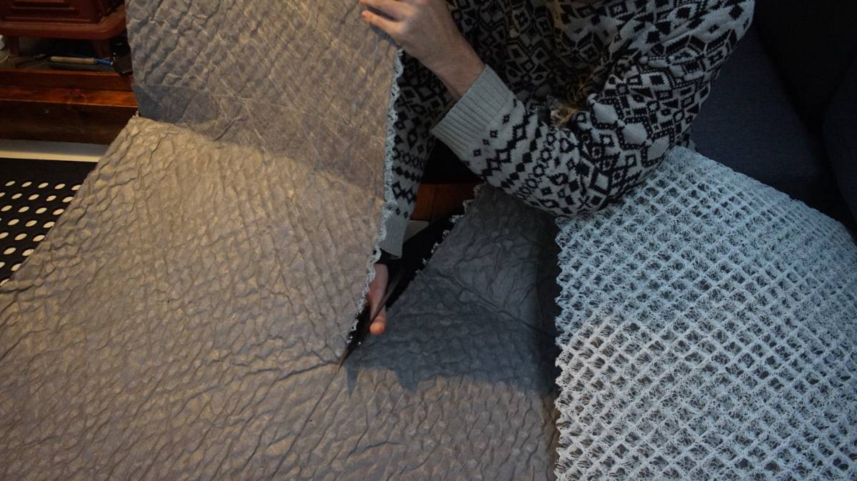 devine cutting a sheet of mesh with a pair of japanese shears