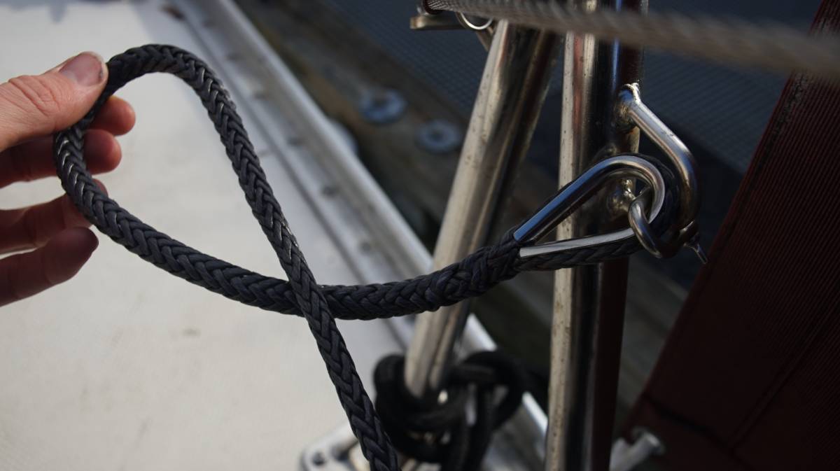 a hand holding a coil of Amsteel and some hardware