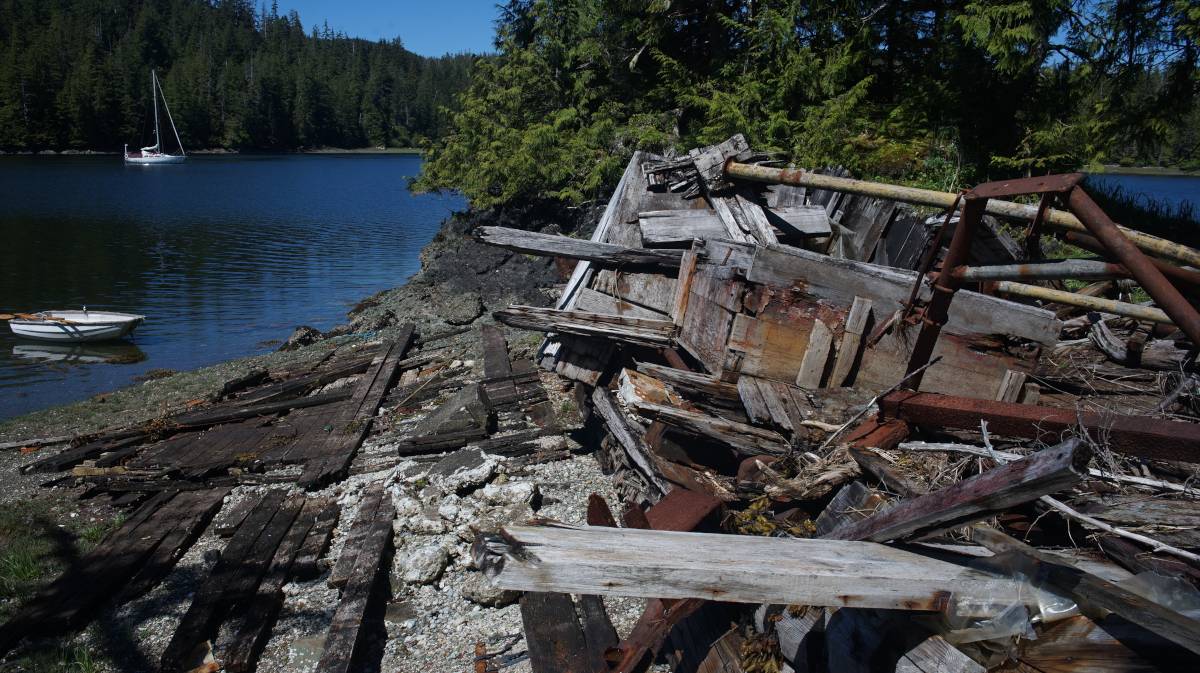 a rusty wreck on a small islet, pino is anchored in the background