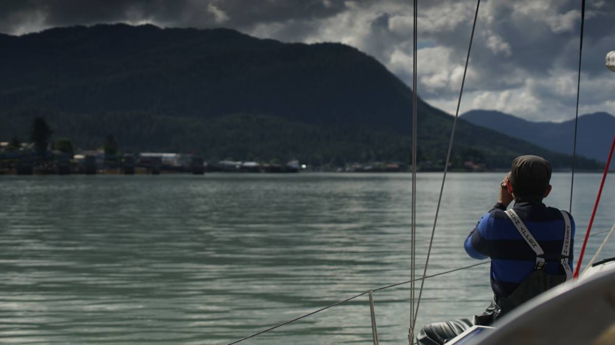 rek sitting near the bow and looking ahead through binoculars