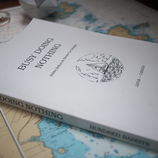 a book named busy doing nothing laying over a chart