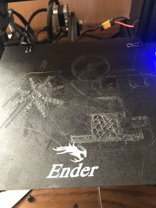 Photo of a print bed with some of the bottom layers of a print stuck to the bed