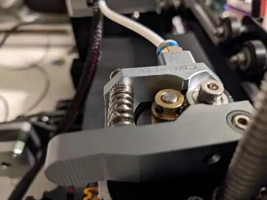 Photo of the Creality metal extruder with the brass hobbed gear too low to reach the filament