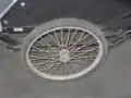 A garden cart wheel is attached to a 3/4 inch axle. The axle is suspended on a leaf springs which are attached to the frame of the trailer. Motorcycle wheels similiar to those used on the trike would be better suited for for this purpose.