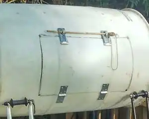 Fig 4: A door can be made using a cut out section of the barrel. In this case we attached it using weather-resistant hinges and hasps found at the local hardware store.