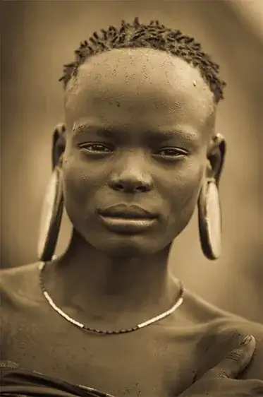 African woman with plugs in ear lobes