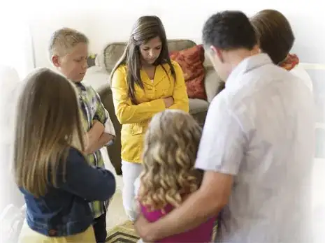 Adults praying in a circle