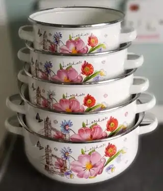 A picture depicting 5 pots stacked on top of each others, each pot being smaller than the next one. The pots are white with colorful paintings (mostly flowers) at the front. The edge of the pots has a metallic looking ring.