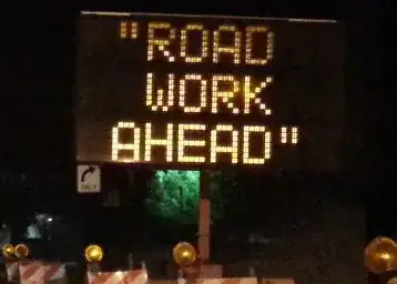 Quotation marks around sign message "road work ahead".