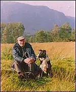 picture of an old man sitting near a dog