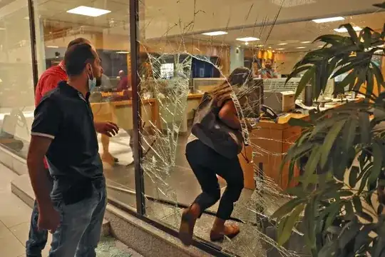 The glass facade of a bank in the Lebanese capital Beirut is broken, after a woman stormed it demanding access to her sister's deposits to allegedly pay for her hospital fees, on September 14, 2022