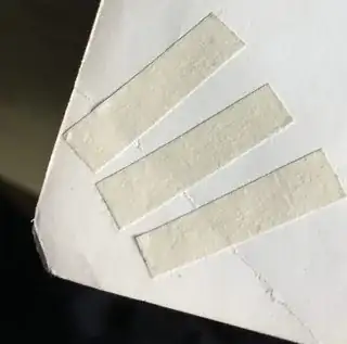 tensioning tape strips applied approximately perpendicular across crease