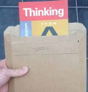 book sticking out of a cardboard envelope