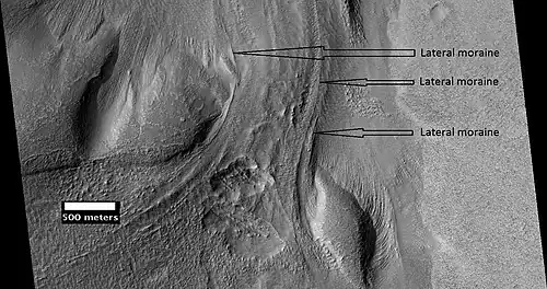 Material Flowing through a crater rim, as seen by HiRISE, under the HiWish program.  Lateral moraines are labeled.