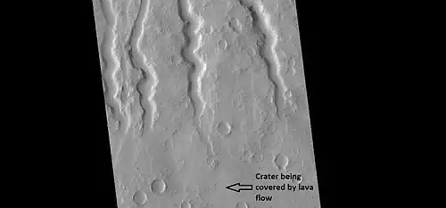 Lava channels on flank of Hecates Tholus, as seen by HiRISE under HiWish program.  A crater has been partially covered over by lava flows.  This crater will be enlarged in the next image.