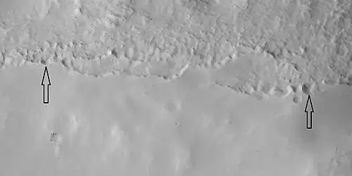 Close view of mantle, as seen by HiRISE under HiWish program. Arrows show craters along edge which highlight the thickness of mantle.  Location is Ismenius Lacus quadrangle.