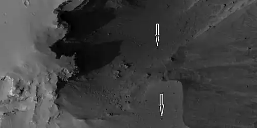 Boulders and their tracks from rolling down a slope, as seen by HiRISE under HiWish program. Arrows show two boulders at the end of their tracks.  Location is Arabia quadrangle.