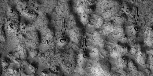 Close view of ejecta, as seen by HiRISE under HiWish program.  Note:  Arrows show examples of boulders sitting in pits.