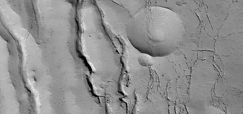 Close view of cracks of various sizes, as seen by HiRISE under HiWish program.  Ice disappears along crack surfaces and makes crack larger.