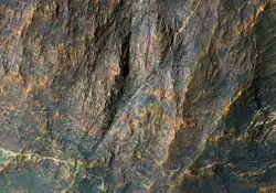 Banded bedrock in Terra Sabaea, in the ancient highlands north of the Hellas basin. The image is about a kilometer wide. Colors are enhanced.