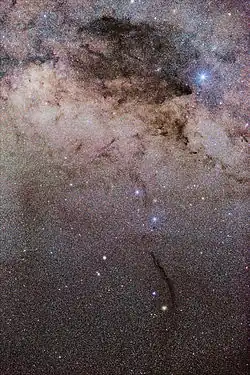 The distinctively thin Doodad nebula can be seen south of the large Coalsack nebula at the top.