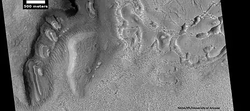 Dipping layers, as seen by HiRISE under HiWish program. Also, Ribbed Upper plains material is visible in the upper right of the picture.  It is forming from the upper plains unit, and in turn is being eroded into brain terrain.