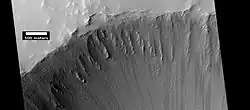 Crater at the top of Ulysses Patera, as seen by HiRISE under HiWish program  Note the lack of a rim.  Volcanic craters do not usually have a rim, as most impact craters do.