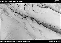 Wide view of spring defrosting.  The dark spots are where the ice has disappeared, thus revealing the dark surface beneath the ice.  Picture taken with HiRISE under HiWish program.