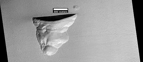 Wide view of triangular depression, as seen by HiRISE. The wall which faces the south pole contains ice in distinct layers that are visible in next image. Location is Hellas quadrangle.