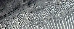 Close view of layers, as seen by HiRISE under HiWish program A ridge cuts across the layers at a right angle.