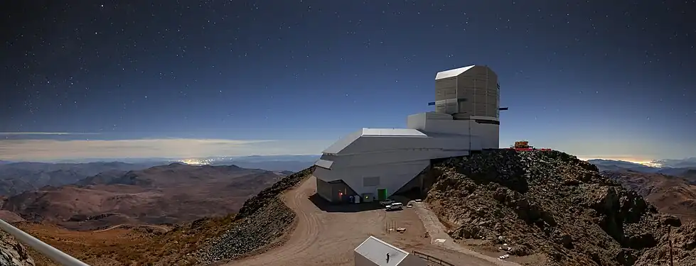 Night Light over Vera C. Rubin Observatory with the brightening of the sky due to the artificial light that can be seen as clusters of bright lights on the horizon
