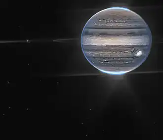 Image of Jupiter showing its rings, moons amalthea and Adrastea, auroras, and atmospheric features.