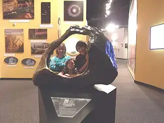 Children posing behind a replica of the Tucson Meteorite at the Arizona Museum of Natural History