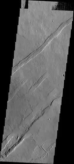 Oti Fossae, as seen by THEMIS.  These parallel graben are found on the northeastern side of Arsia Mons; they are in line with the NE/SW trend of the three volcanoes in Tharsis.