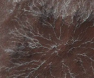 Star burst Channels caused by escaping gas, as seen by HiRISE.  Star burst channels, also called spiders, may be about 500 meters in diameter and 1 meter deep.