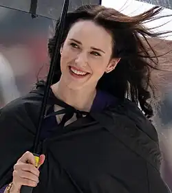 Lois Lane actress Rachel Brosnahan during filming in 2024, holding an umbrella
