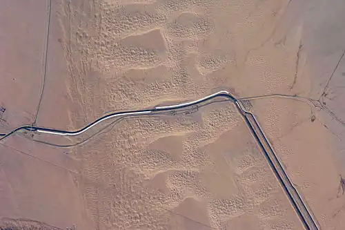 This image captures about 15 kilometers (9.3&nbsp;mi) of the All-American Canal just west of Yuma, Arizona; photo is taken of the southern section of the Algodones Dunes