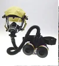 A powered air-purifying respirator with a belt-pack filter-blower that feeds air to the elastomeric mask.