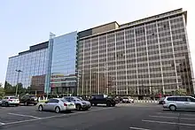 A photo of a building whose left side is blue glass, and right side is brown