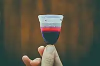 A filled menstrual cup after use. With practice, it is possible to remove a bell-shaped cup without spilling or bloodying the hands.