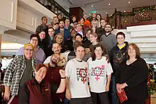 A group of people standing on a staircase in a hotel facing the camera.