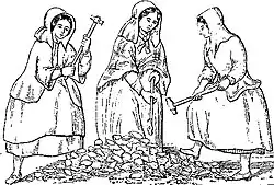 Three women wearing heavy clothing and long bonnets, carrying long hammers, standing around a pile of rocks