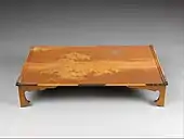 Masă japoneză pentru scris; secolul al XX-lea timpuriu; lemn lăcuit cu accesorii de argint și diverse alte materiale; înălțime: 12,3 cm, lungime: 60,69 cm, lățime: 36,83 cm; Muzeul Metropolitan de Artă (New York City)