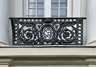 Balconet în stil neoLudovic al XVI-lea la stradă, cu un medalion cu monograma proprietarului (Leonida Gussi)