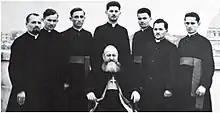 Frențiu sitting among priests including Fr. Alexander Ratiu. Coriolan Tamaian is the first person from the right.