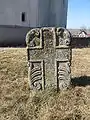 Piatră de mormânt veche din curtea bisericii ("1792. Supt aceasta cruce ... odinește ro...bul lui Dmnezeu O...ncuce ...")