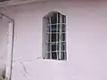 Fereastră, unde se poate vedea lemnul şi tencuiala ce îl acoperă