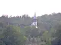 Biserica de lemn văzută din partea opusă a satului