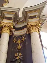 Tabloul principal al altarului este flancat de coloane corintice sub care se află un tabernacol