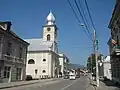 Calea Transilvaniei din oraşul Câmpuluntg Moldovenesc. Biserica se află pe partea stângă.